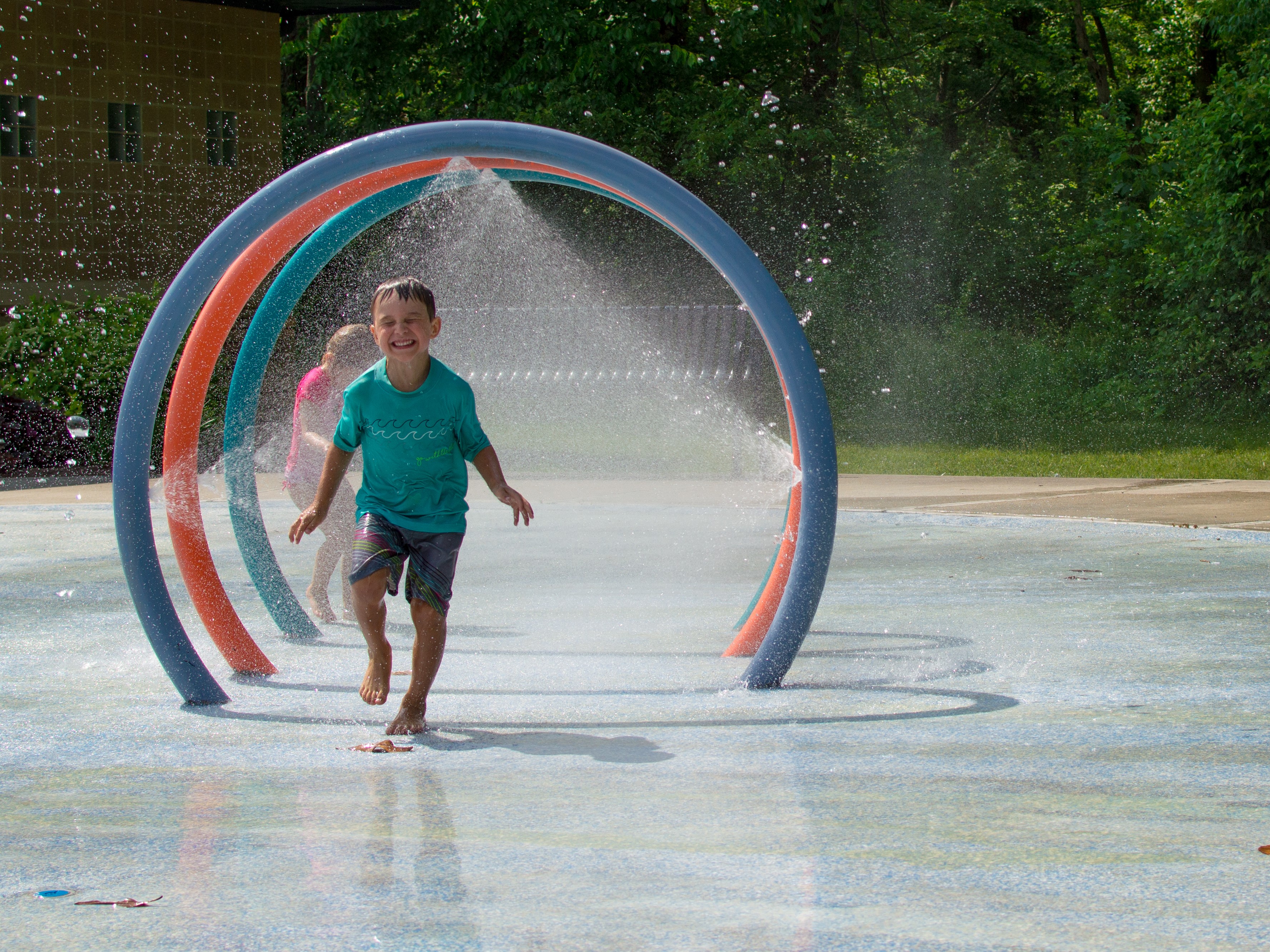 child  running through sprinkler